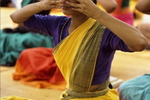 Voyageuse en méditation sur les ghats de Varanasi au lever du soleil avec le Gange